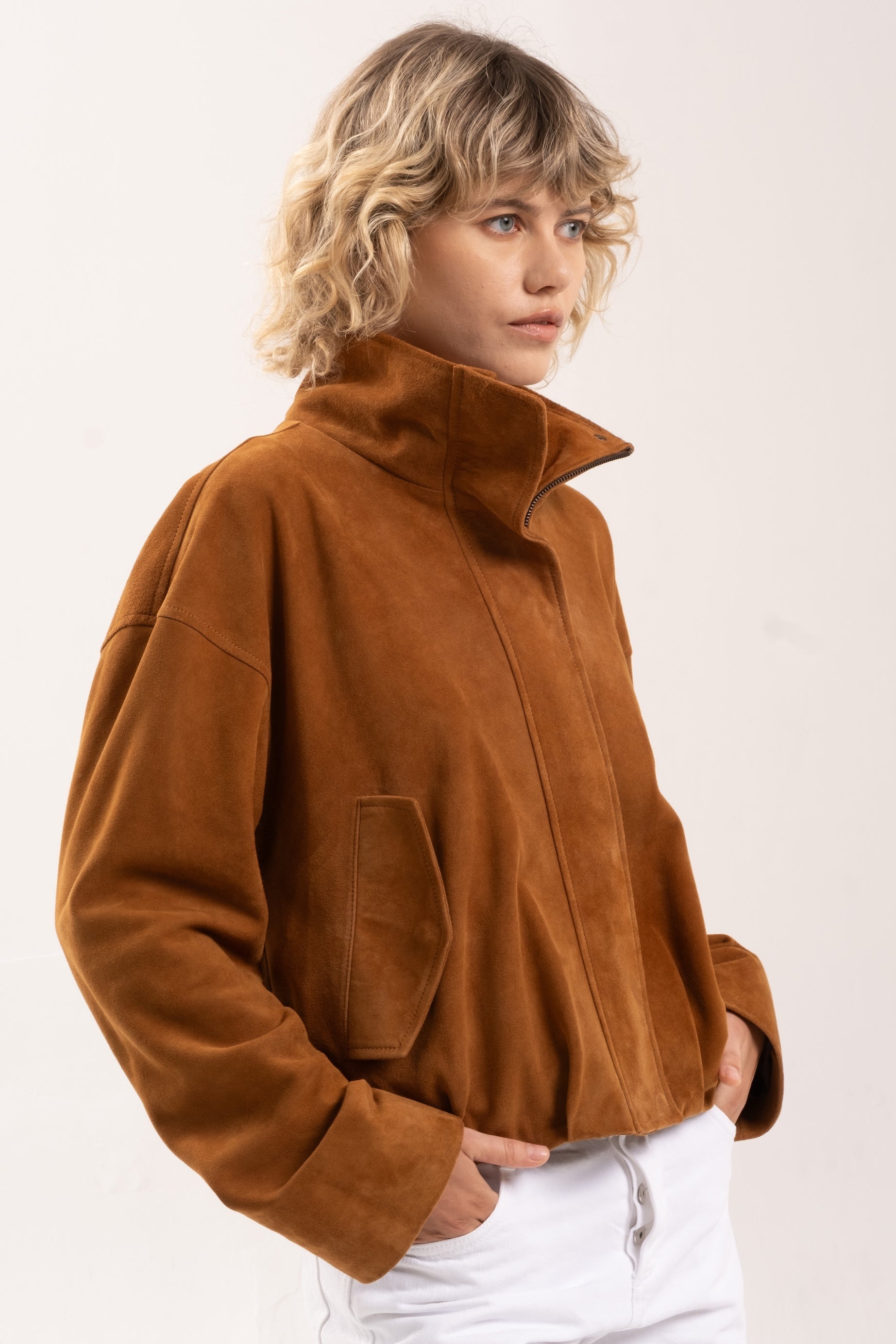 Model wearing the 2NDSKIN Arabella funnel neck jacket in Tobacco suede